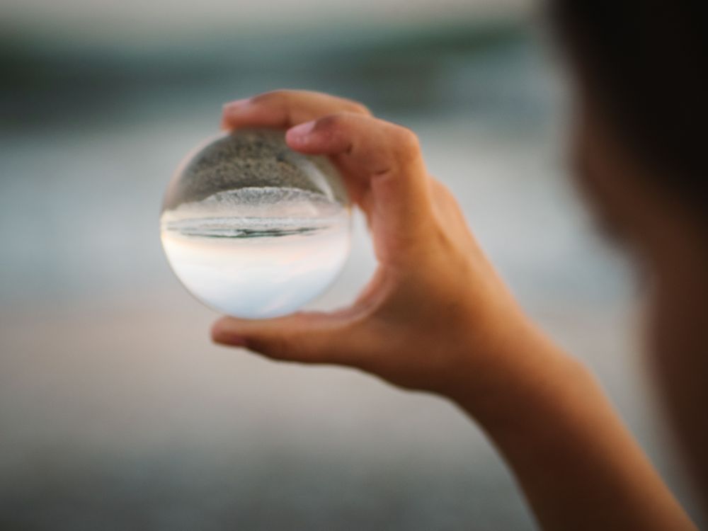 Girl playing with glass ball on seaside