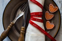 Red ribbon wrapped napkin on table setting