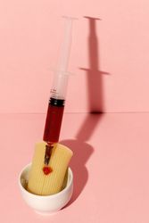 Stuffed pasta with red sauce in syringe