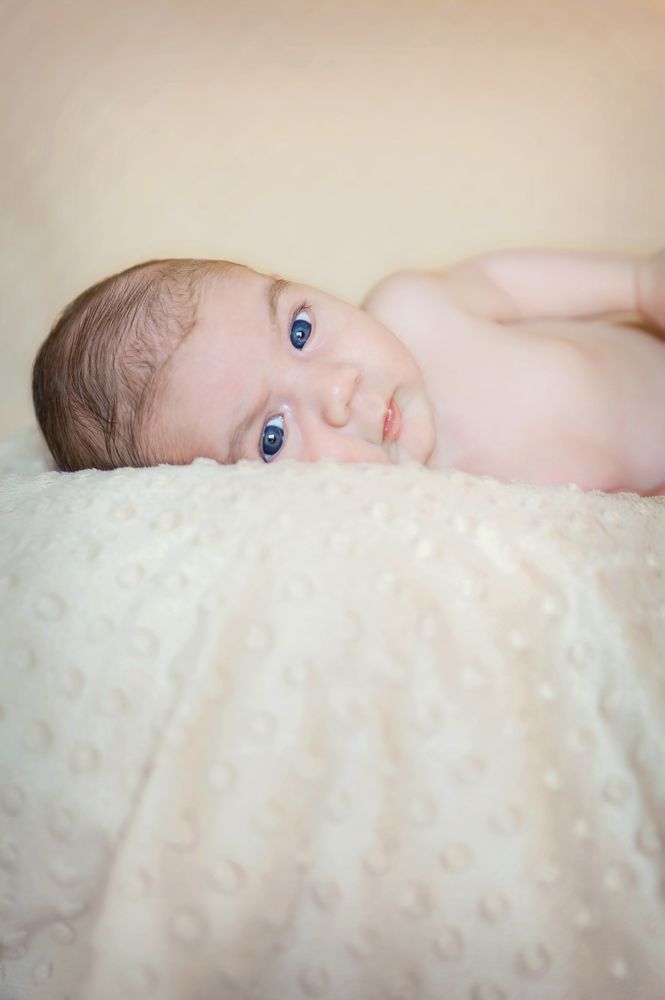 Portrait of newborn baby lying down over a blanket