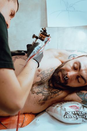 Man giving client a tattoo