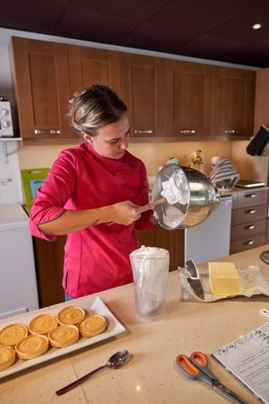 Female cook taking whipped cream out of bowl