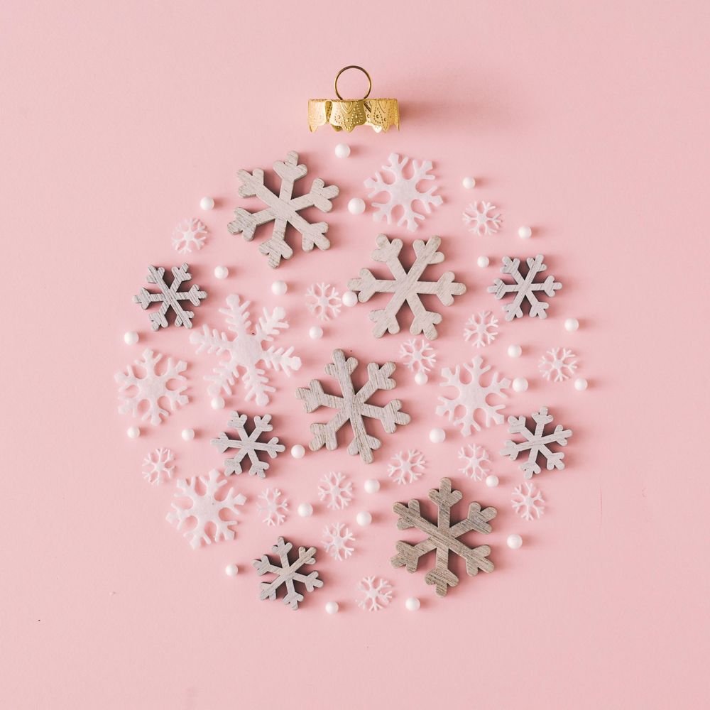 Snowflakes making shape of holiday decoration on pink background