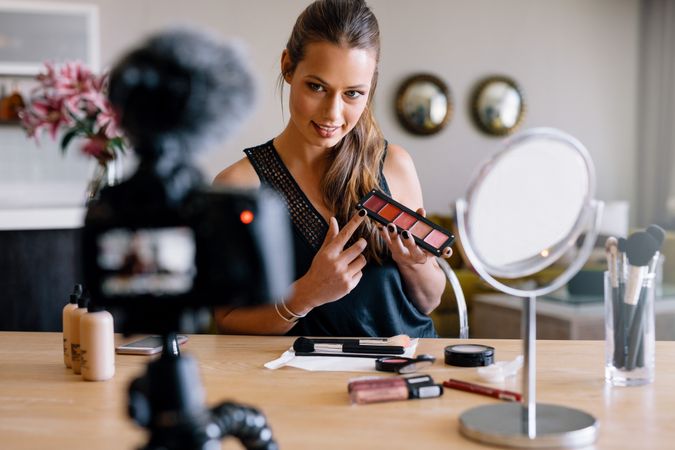 Makeup artist showing lipstick palette to her camera