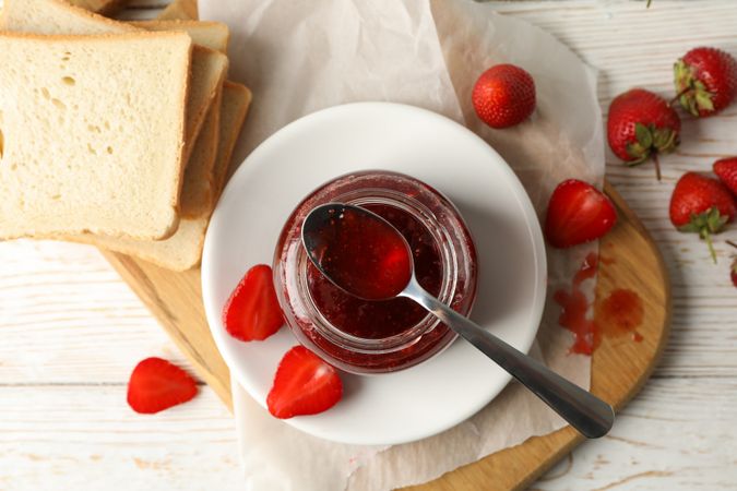 Composition with strawberry jam on wooden background, top view