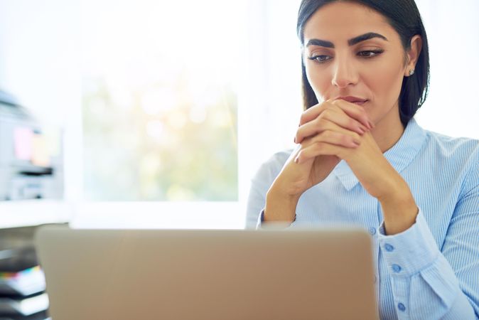 Woman intensely reading something on laptop