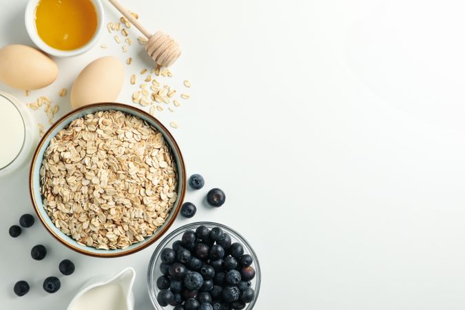 Composition with oatmeal flakes on plain background, top view. Cooking breakfast