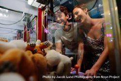 Smiling couple playing coin operated games at a gaming parlour 5lnQob
