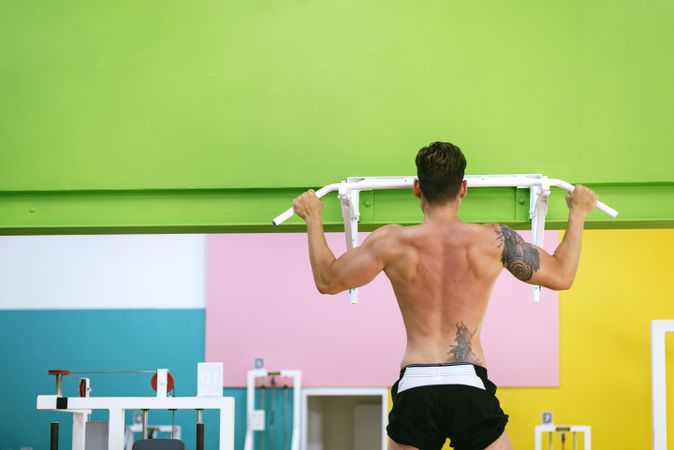 Back of man working out in a fitness club with copy space