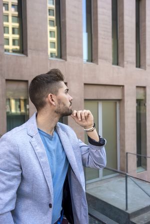 Young bearded man in front of building wearing smart casual