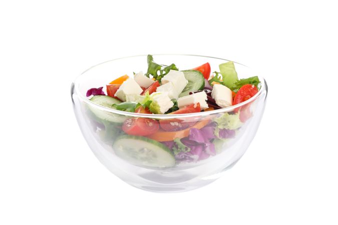 Glass bowl with fresh salad isolated on plain background