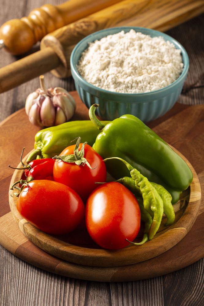 Wooden table with ingredients for pizza.