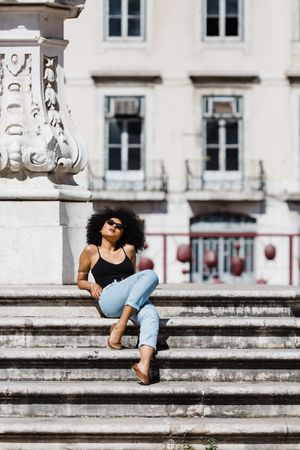 Black female sitting on stairs outdoors