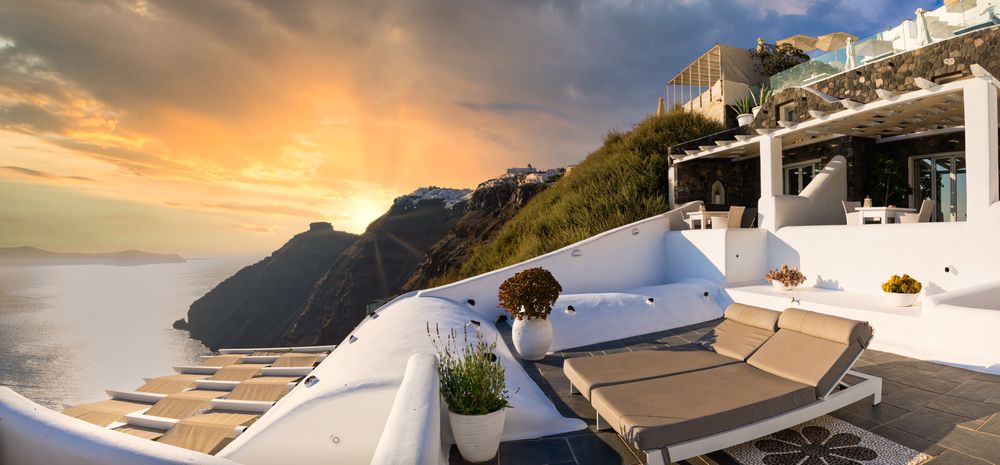 Sunset over hill in Santorini as seen from patio with two patio chairs