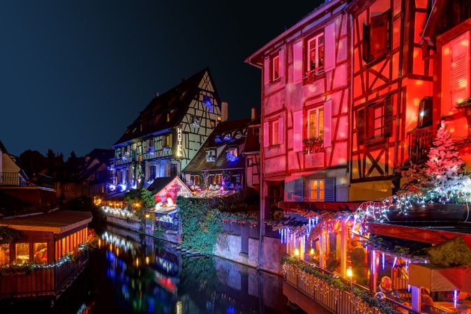 Buildings along river in Alsace, France lit up for Christmas