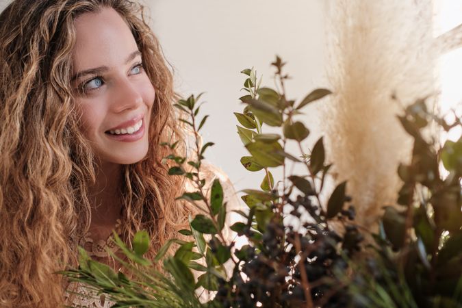 Smiling woman with long hair against green foliage