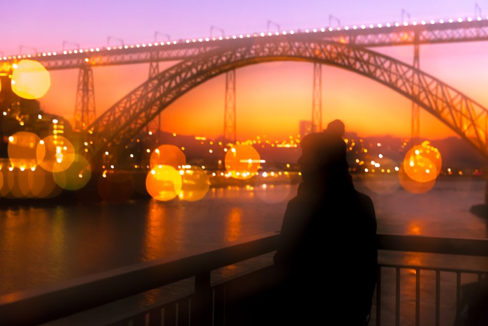 Anonymous woman standing on embankment in evening