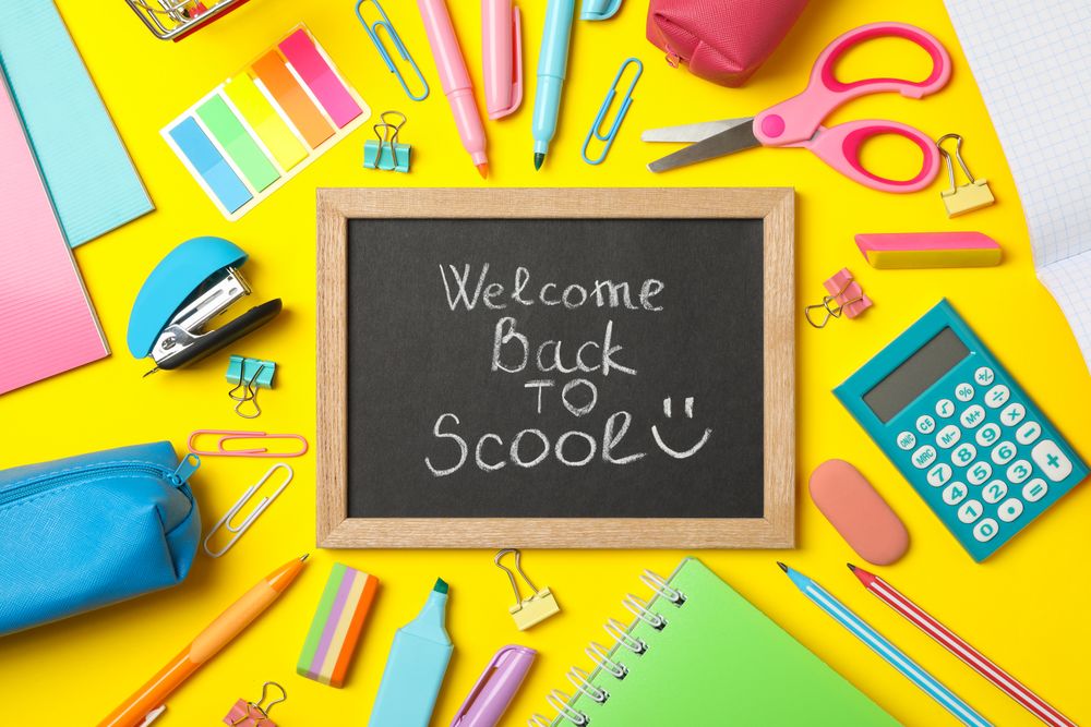 Text Welcome back to school and school supplies on yellow background