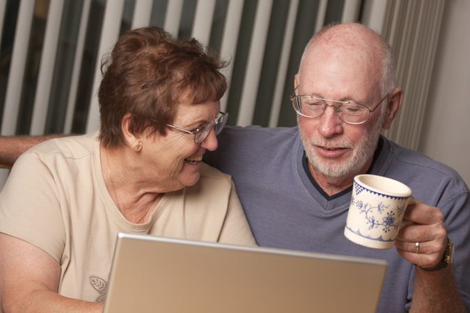 Smiling Mature Adult Couple Having Fun on the Computer