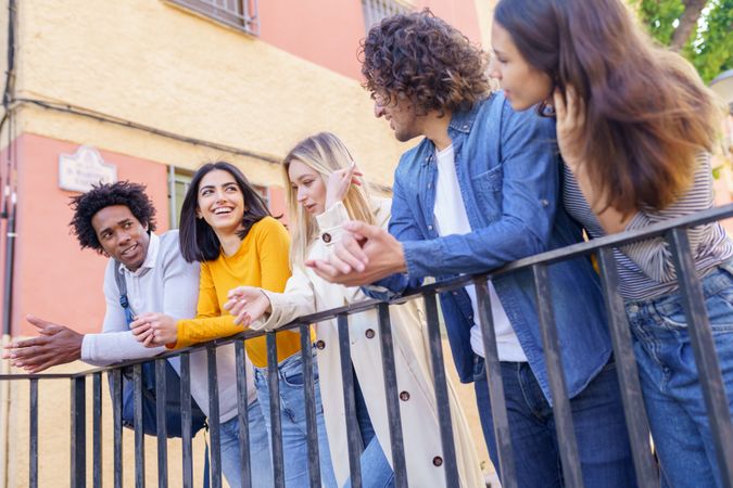 Portrait of happy male and female friends chatting together outside