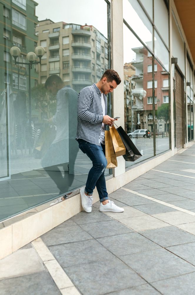 Man with shopping bags and mobile