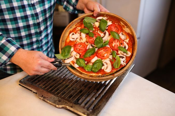 Cropped image of man holding Italian margarita pizza