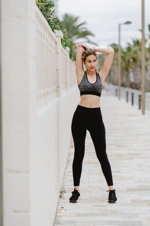 Woman in sports clothing stretching before exercise at seaside