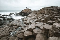 Female standing on cliff and contemplating