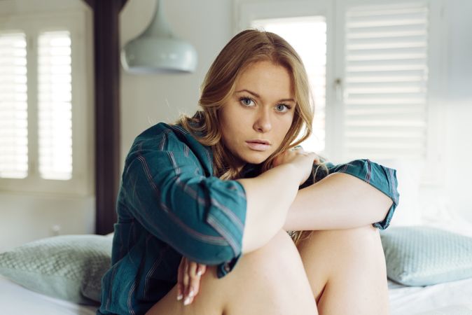 Young female sitting on bed