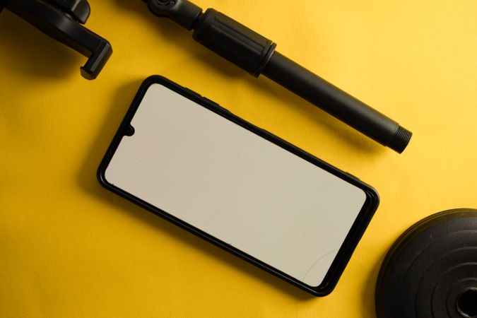 Mock up phone and accessory pieces on yellow background