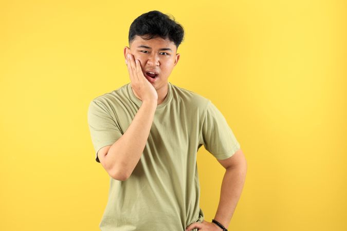 Asian Young Man Holding His Cheek, Dental Problem Concept