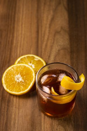Negroni cocktail with orange, on wooden background.