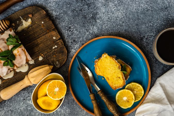 Top view of tasty lemon cake with fresh mint served on blue plate with coffee