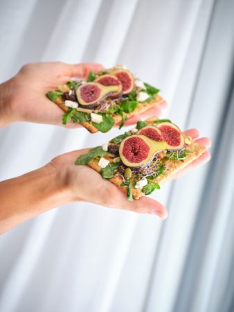 Crop person with arranged fruit slices in both hands