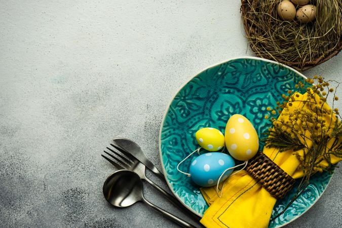 Easter table setting with yellow and blue eggs on plate