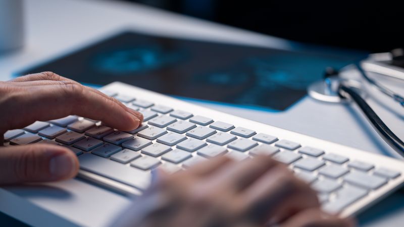 Doctor Typing on Keyboard in Office