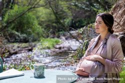 Relaxed pregnant young woman reading newspaper outside bY8Oj4