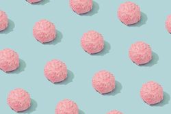 Pastel pink ice cream scoops  in rows on blue background