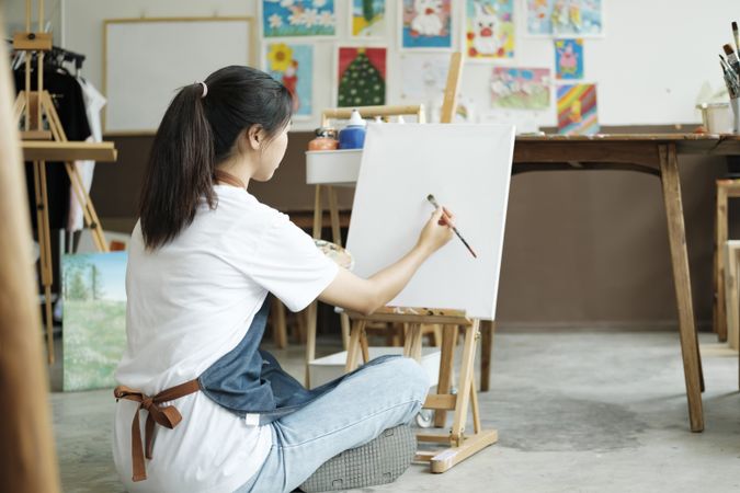 Crafting Inspiration. Female Artist Sketching and Painting in Workshop