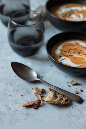 Bits of bread and spoon near pumpkin cream soup