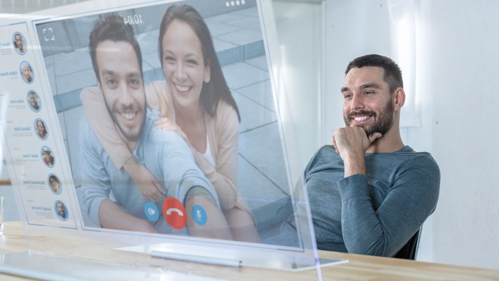 In the Near Future Man Makes Video Call from Computer with Transparent Display to His Friends.