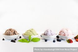 Side view of four small bowls of colorful ice cream 4ZX290