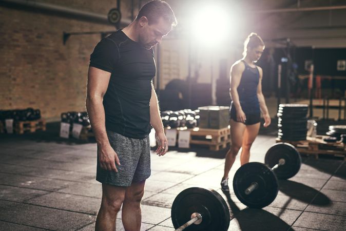 Two crossfit trainers preparing to lift heavy weights