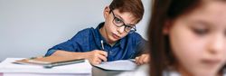 Teen writing in notebook at school