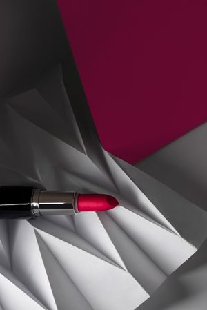 Pink lipstick on raised chevron. Product and make up contemporary concept