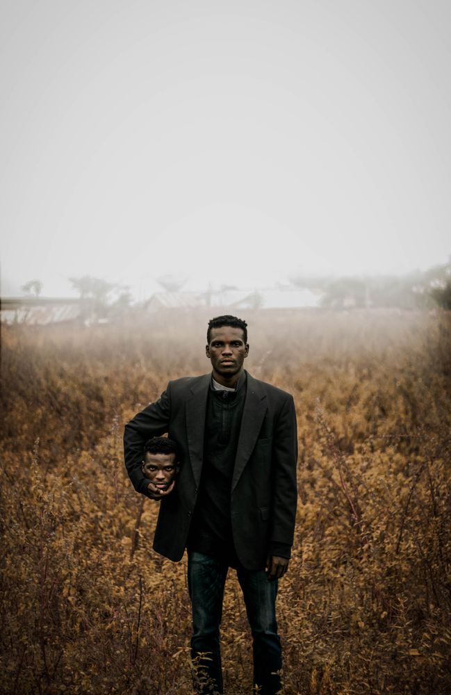 Graphic image of man in dark jacket holding his duplicate head