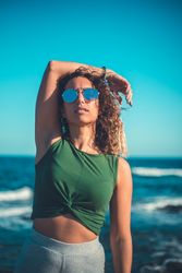 Stylish woman standing near sea