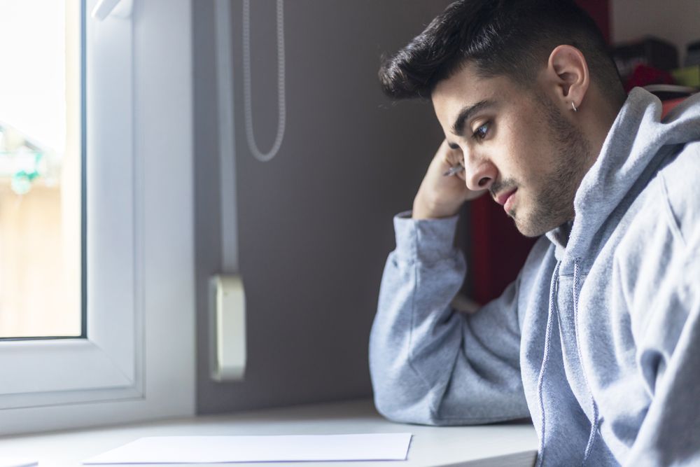 Male student writing in a notebook