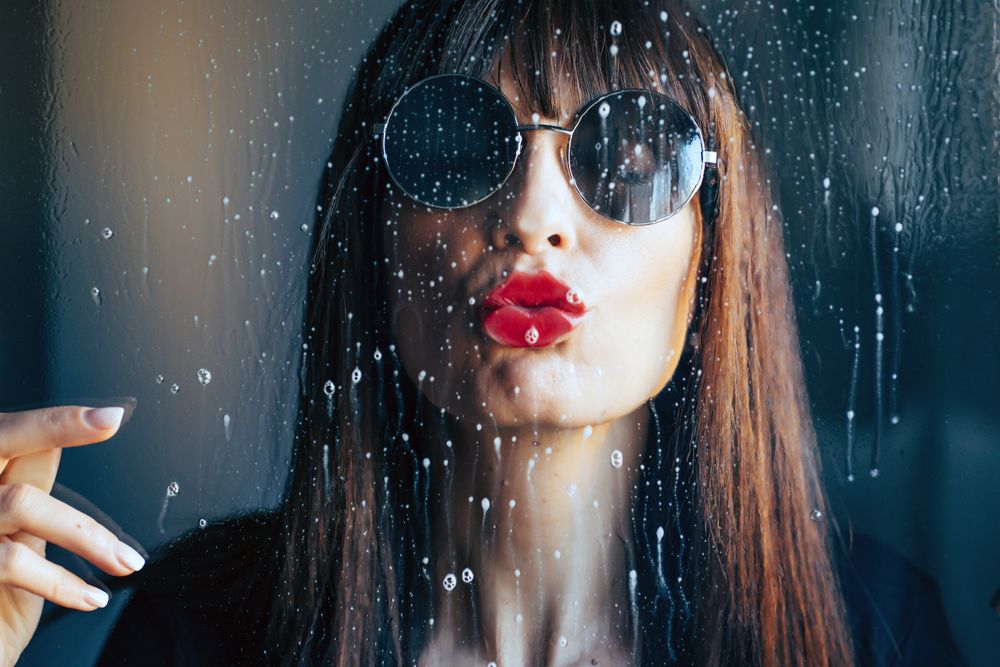 Stylish woman kissing glass
