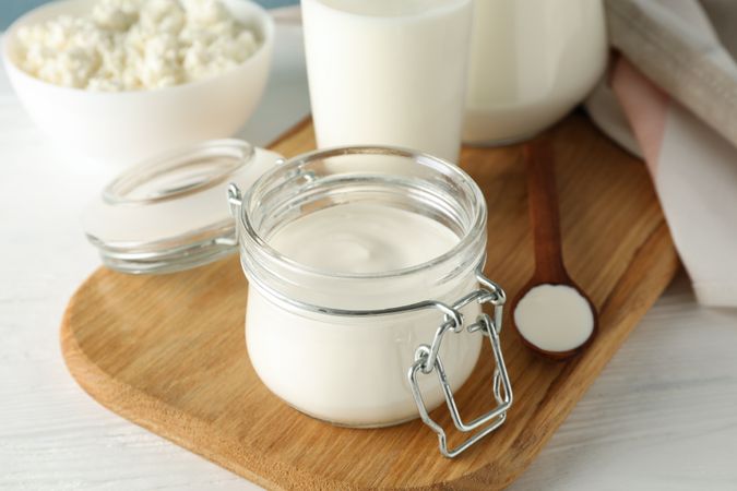 Fresh dairy products on plain wooden table, copy space
